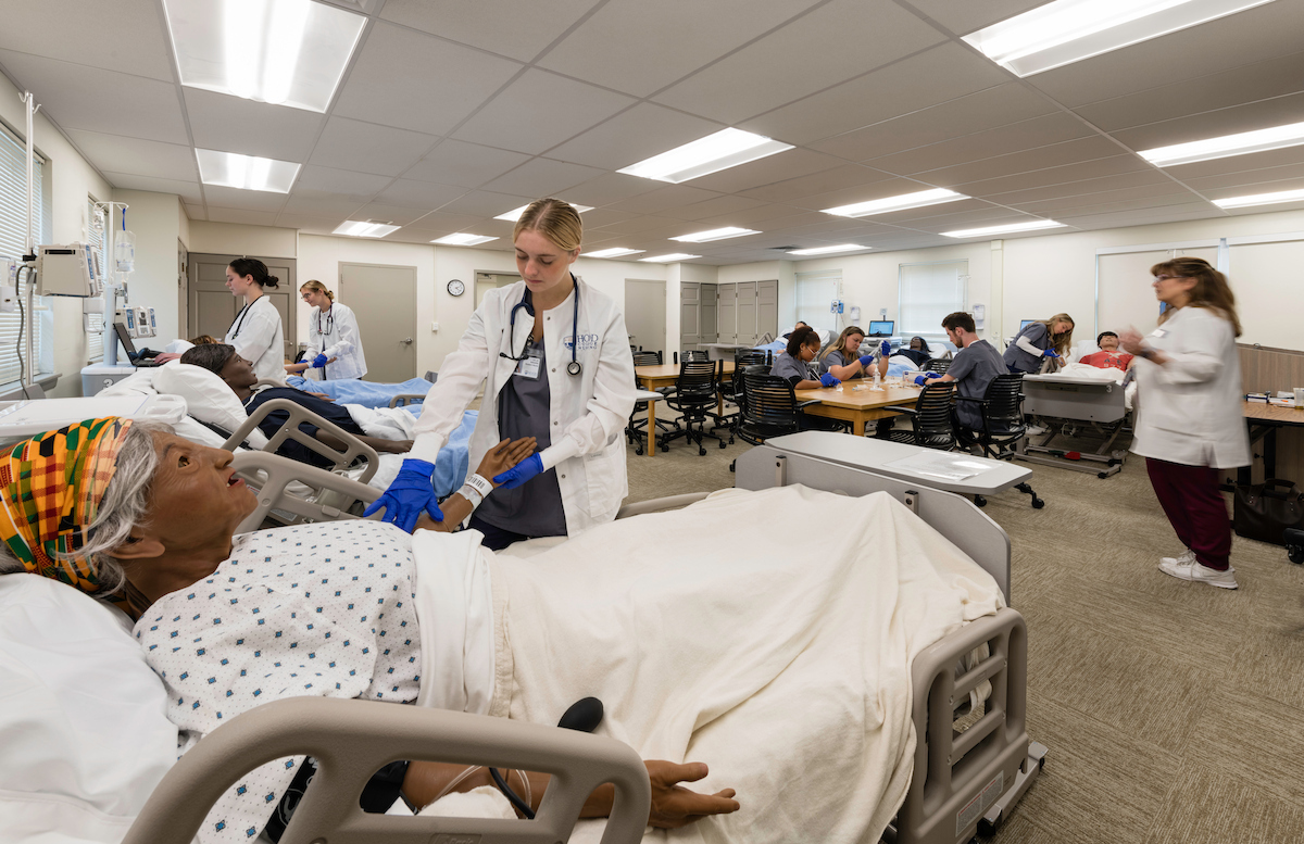A Hood College Nursing Student works on a simulation mannequin