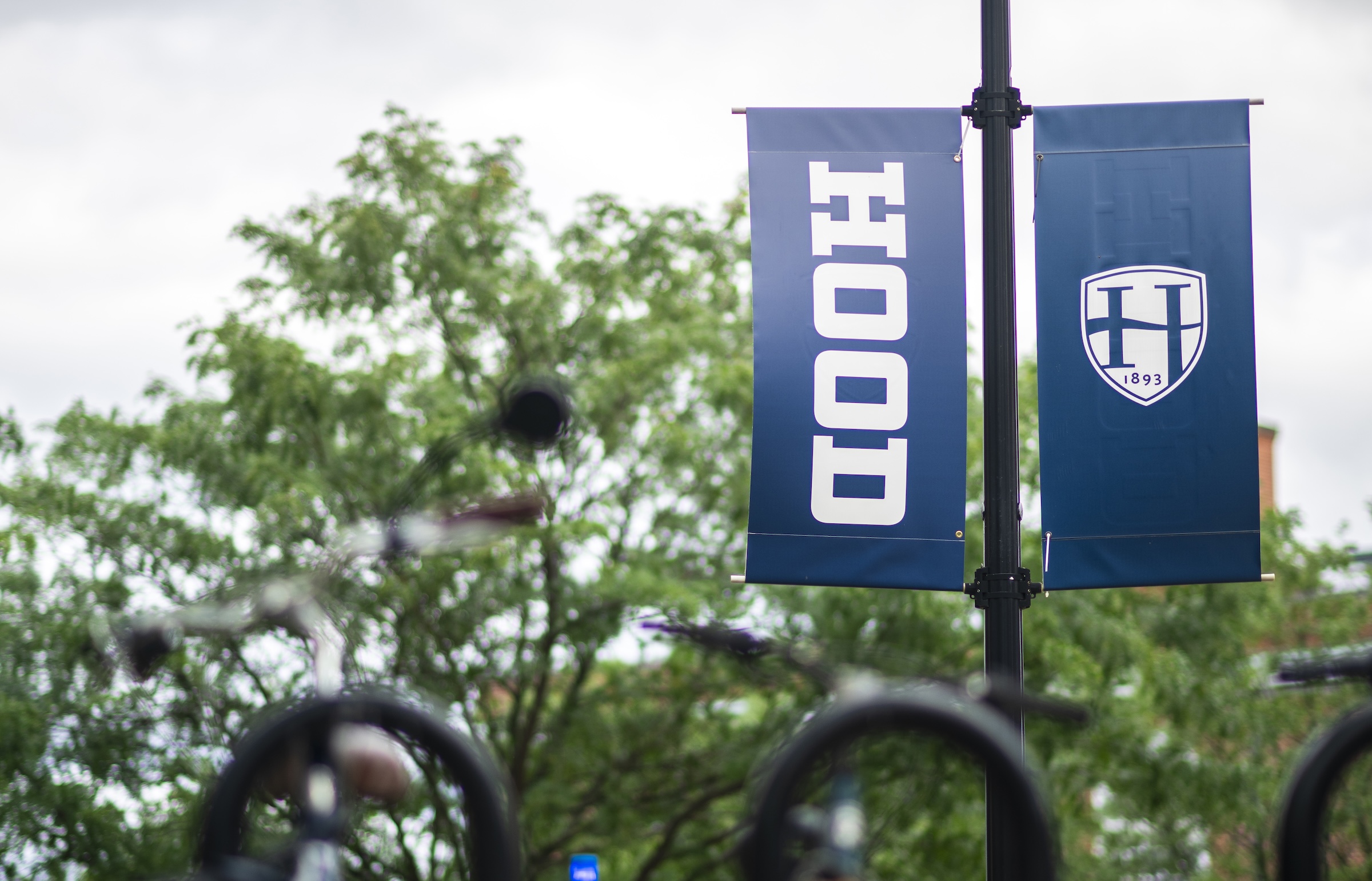 A photo of a bike rack beneath a banner on Hood's campus.