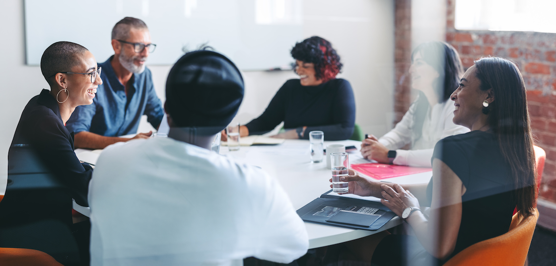 A group of working professionals gathered around a board table.