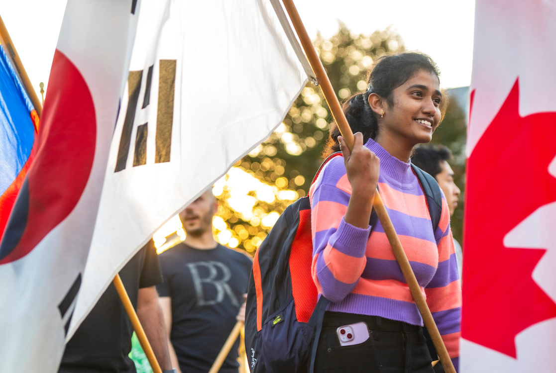 A student marching in the parade of flags.