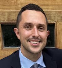 A photo of Anthony Lombardi wearing a suit and tie.