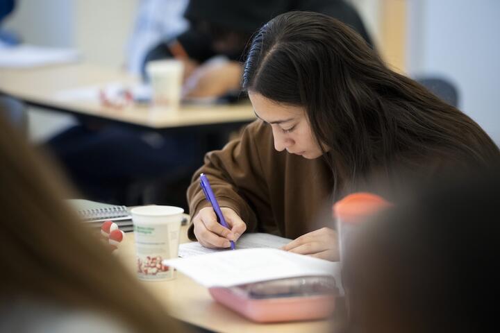 A student taking notes in the classroom.